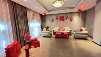 A modern living room with a sofa set, a coffee table, and decorative red elements.