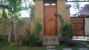 A wooden door with a small porch and potted plants. - Blue Royal Amed (Karangasem)