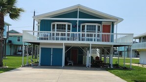 Une maison à deux étages avec un balcon, un garage et une véranda.