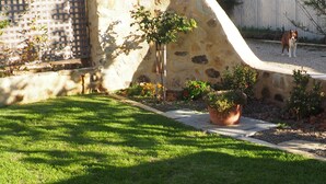 A well-maintained lawn with a stone wall and a wooden fence. - Cobblers Cottage B & B Accommodation (Willunga)