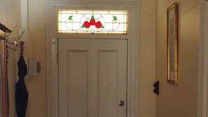 A white door with a stained glass window above it, a wooden bench to the left, and a rug leading to the door. - Cobblers Cottage B & B Accommodation (Willunga)