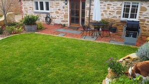 A stone house with a patio, a barbecue grill, and a lawn. - Cobblers Cottage B & B Accommodation (Willunga)