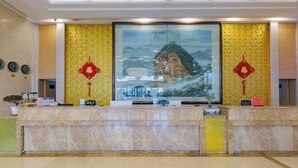A reception area with a marble counter, a large framed painting, and decorative red ornaments.