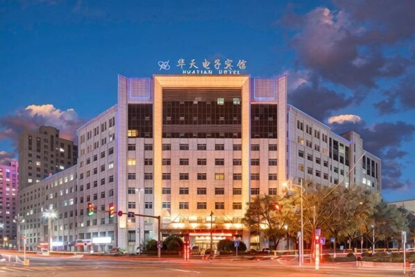 A multi-story hotel with a prominent entrance, signage, and a well-lit facade.