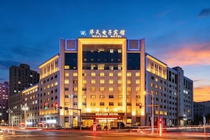 Un hotel de varios pisos con una entrada destacada y señalización.
