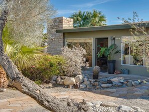 A modern house with a stone facade, a stone patio, and various plants. - Canary Palms - Iconic Midcentury Oasis (Palm Springs)
