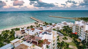 A coastal hotel with multiple buildings, a beach, and a pier. - LA AMADA CANCUN LUXURY CONDO 3 BR STEPS FROM BEACH MARINA (Isla Mujeres)
