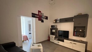 A modern living room with a sofa, TV, and entertainment unit. - APARTMENT, VACATION HOME CATANIA (Catania)