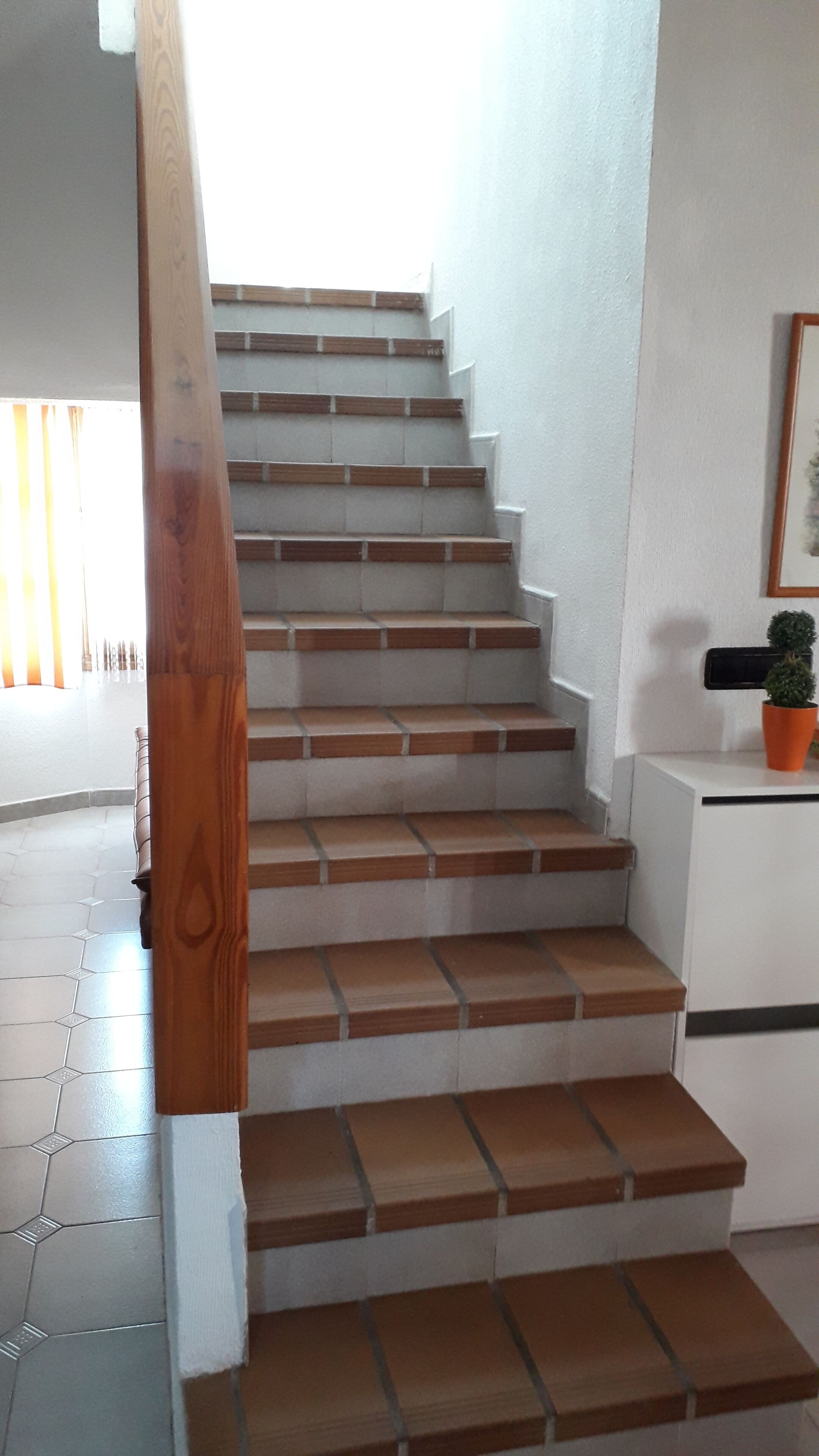 A staircase with wooden steps and a white wall.
