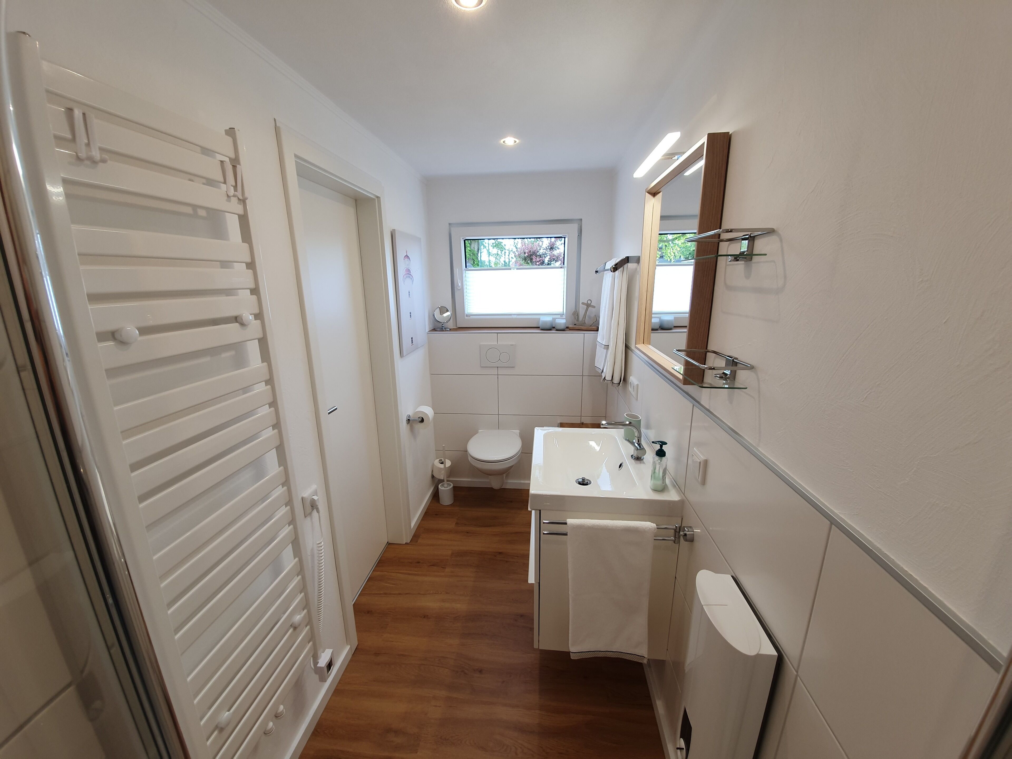 Une petite salle de bain comprenant des toilettes, un lavabo et un miroir.