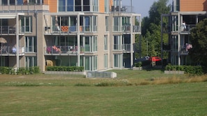Um edifício residencial com várias andares, varandas, janelas amplas e telhado plano.