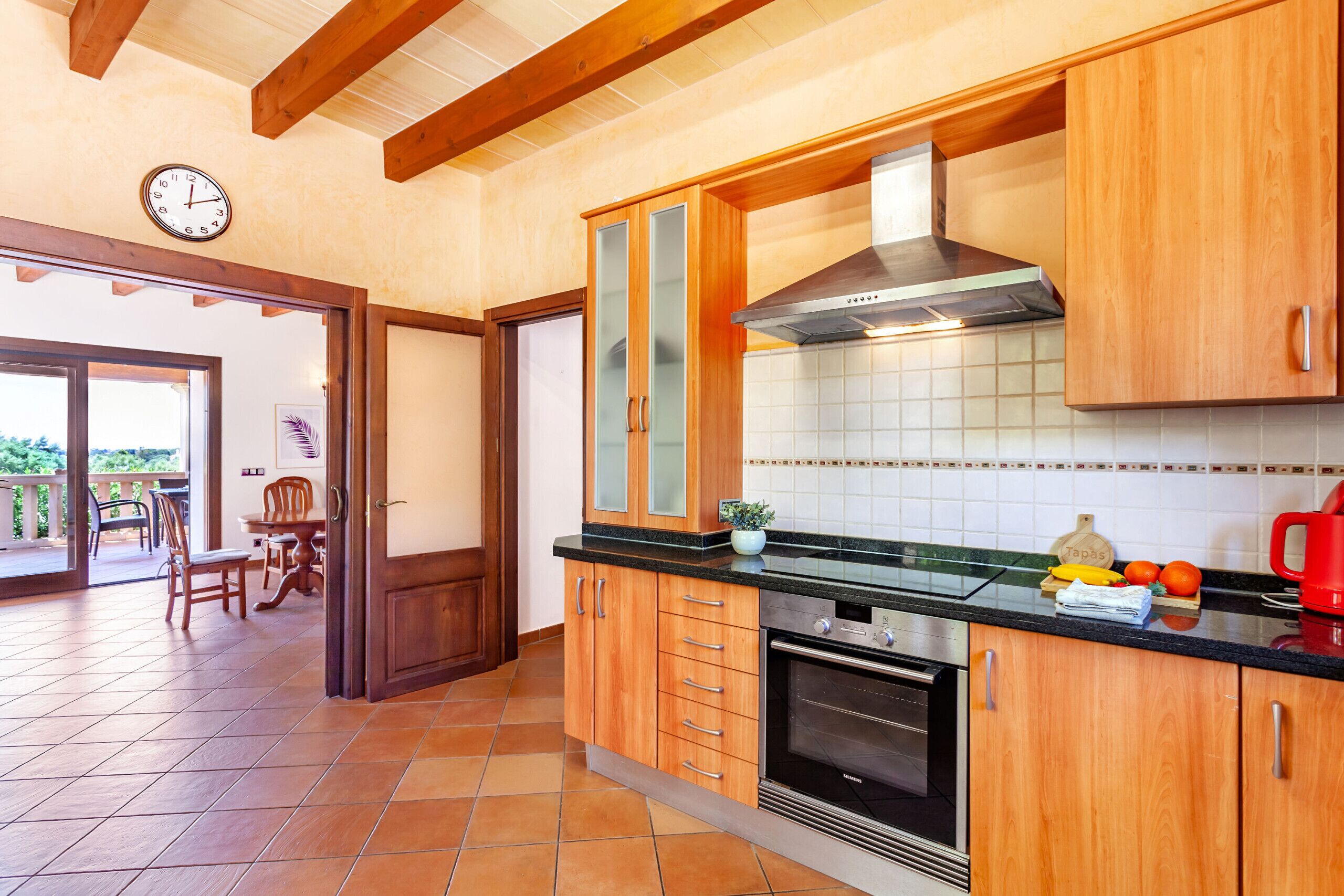 A kitchen with wooden cabinets, a stainless steel range hood, and a Siemens oven.