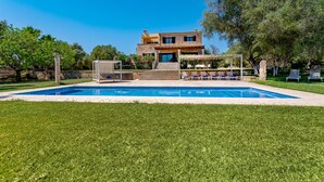 A two-story house with a swimming pool, outdoor seating, and a well-maintained lawn. - Bassa Seca by dracmallorca (Santanyi)