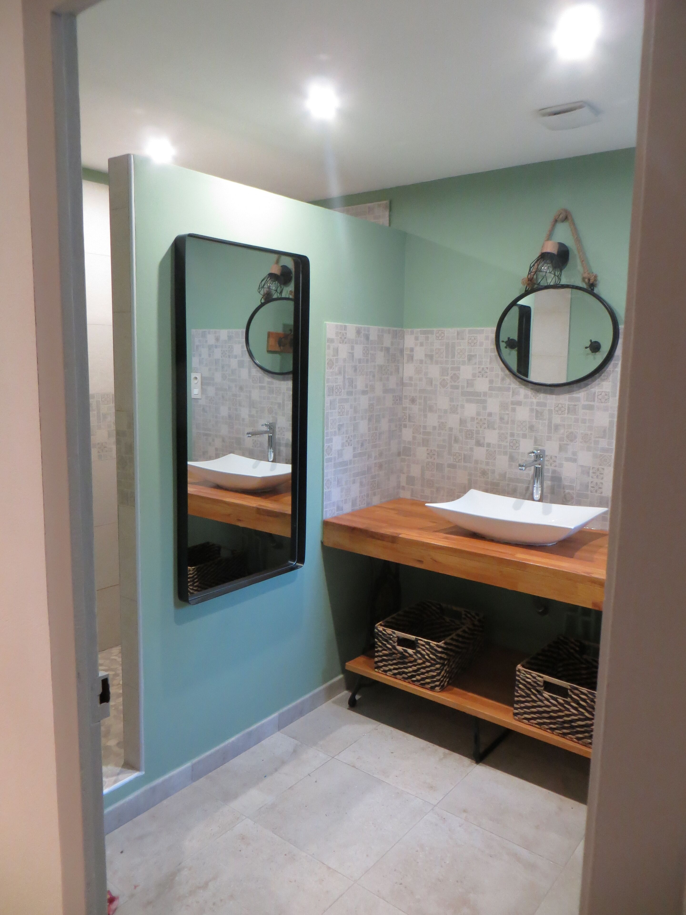 A bathroom with two sinks, a mirror, and tiled walls.
