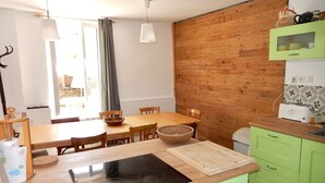 Una cocina moderna con muebles de madera, estufa integrada y un comedor con mesa y sillas.