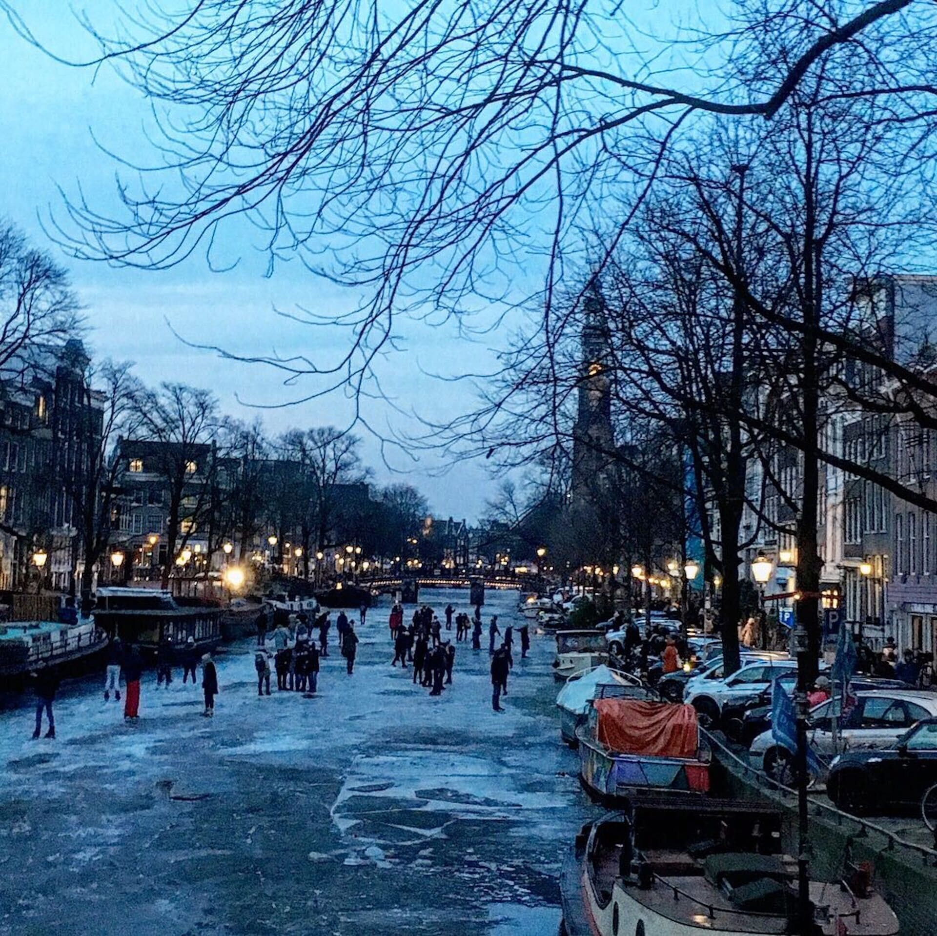 A riverside area with boats, people, and buildings along the water.