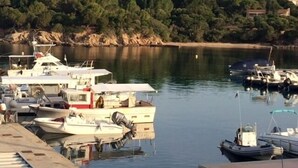 A marina with several boats docked, surrounded by rocky terrain and greenery. - Villa Côté Port in the heart of the fishing village with sea view. Air conditioning, WIFI (Sartène)