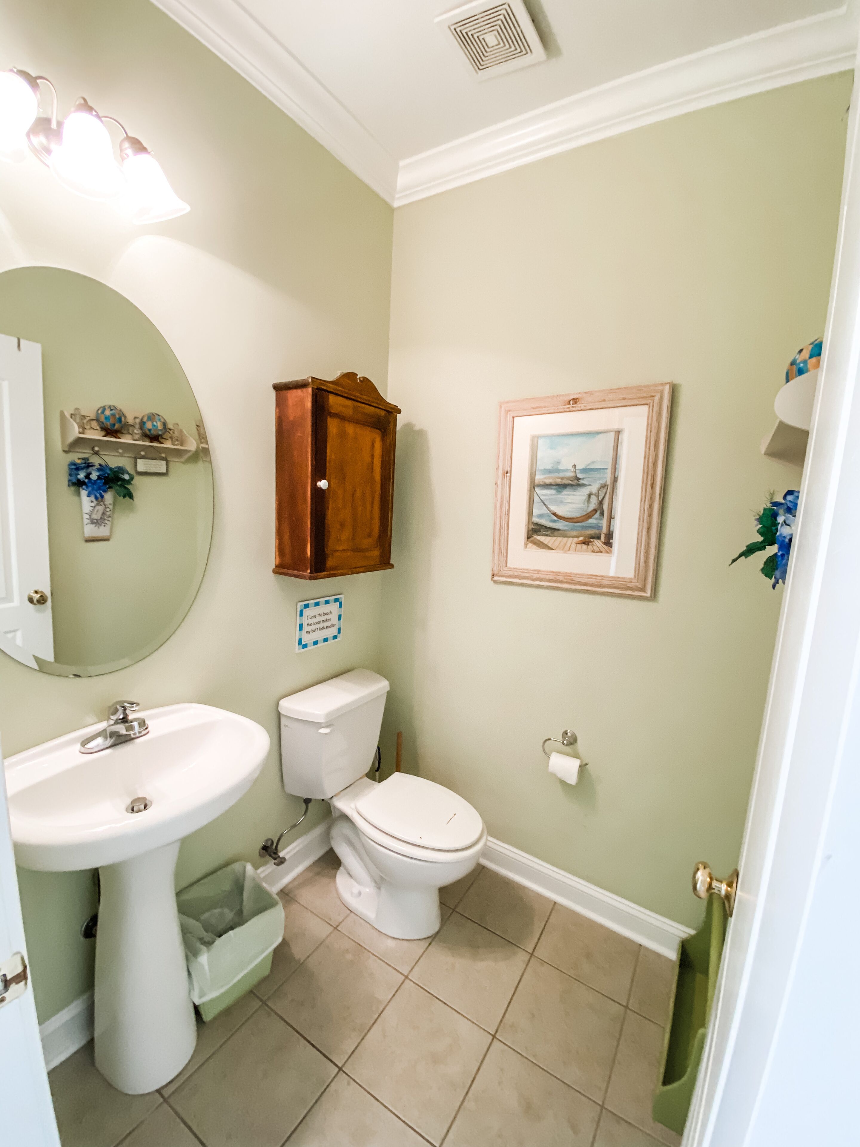 Ein Badezimmer mit Waschbecken, Toilette und einem gerahmten Bild an der Wand.