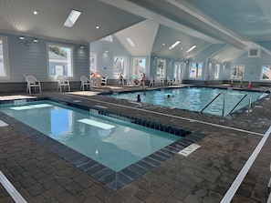 An indoor swimming pool with clear water, tiled walls, and a brick floor. - 5 BR/4.75 BA Beach Home/Golf Carts/Gameroom/Pools/6 Bikes  Sleeps 17  (Surfside Beach)