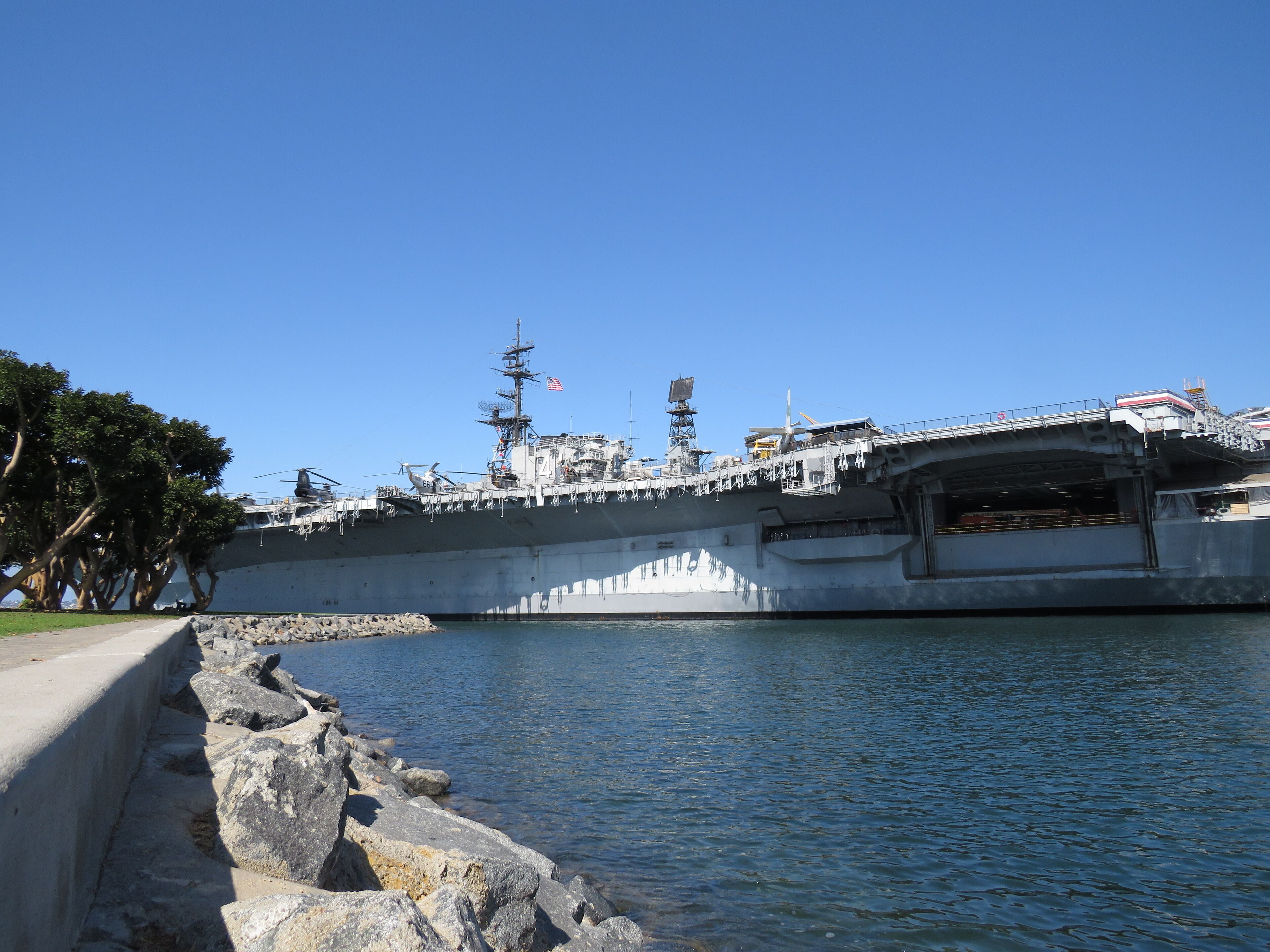 Un porte-avions était amarré dans un port, sous un ciel dégagé.