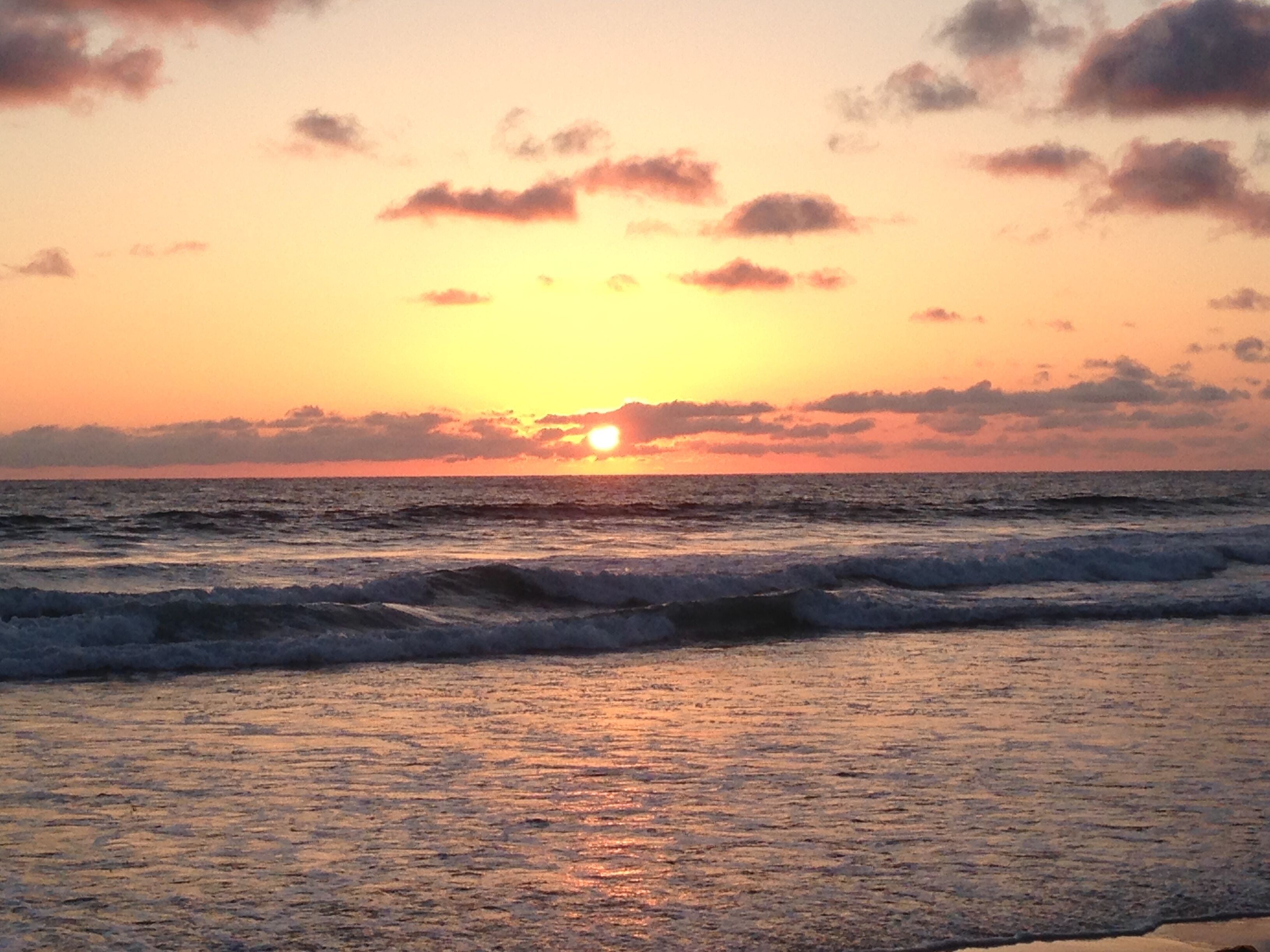 Tramonto sull'oceano con le onde.