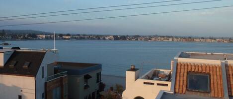 Zona residencial con vista a una gran masa de agua, probablemente un lago o río, y un horizonte urbano lejano.