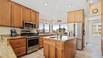 A spacious kitchen with wooden cabinets, stainless steel appliances, and a large island.