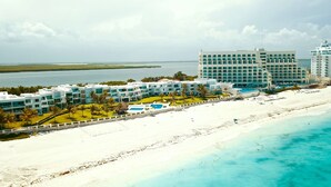 Ein Resort mit mehreren Gebäuden, einem Strand und einem Poolbereich.