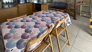 Una cocina moderna con comedor, pared de piedra y escalera de caracol.