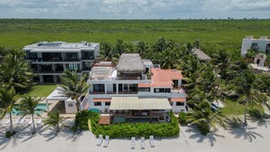 A beachfront property with multiple buildings, a swimming pool, and palm trees. - LUXURY BEACHFRONT VILLA  Includes 3 Pools, Wifi, Best Snorkeling & Kayaking Bay (Tulum)