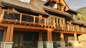 A two-story log cabin with a balcony and a stone chimney. - Exceptional Ski-in/Walk-out Home - 4100 Sft (Golden)