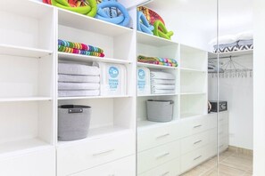 A closet with shelves holding folded towels and a basket.