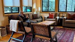 A cozy living room with a sofa, chairs, a coffee table, and a rug.