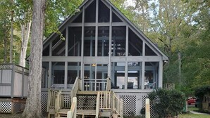 A two-story cabin with large windows and a deck.