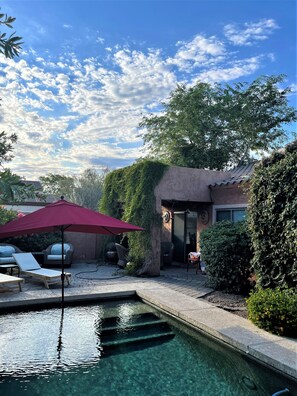 A backyard with a swimming pool, outdoor furniture, and a red umbrella. - Beautiful Home w/ Pool; Clean, Quiet, Secure - near Mayo Clinic; Hiking/Golfing (Scottsdale)