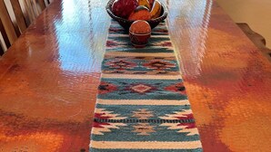 A wooden table with a colorful woven runner and a bowl of decorative items. - Beautiful Home w/ Pool; Clean, Quiet, Secure - near Mayo Clinic; Hiking/Golfing (Scottsdale)