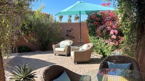 A patio with wicker furniture, a glass table, and a potted plant. - Beautiful Home w/ Pool; Clean, Quiet, Secure - near Mayo Clinic; Hiking/Golfing (Scottsdale)