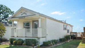 A single-story house with a covered porch, a satellite dish, and a sign reading "OVERLOOK".
