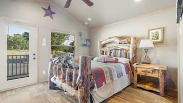 Un dormitorio con cama, mesita de noche, ventilador de techo, decoración de estrellas y ventana.
