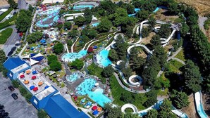 Vue aérienne d’un parc d’attractions doté de nombreuses toboggans aquatiques, de plusieurs piscines et d’un vaste parking.