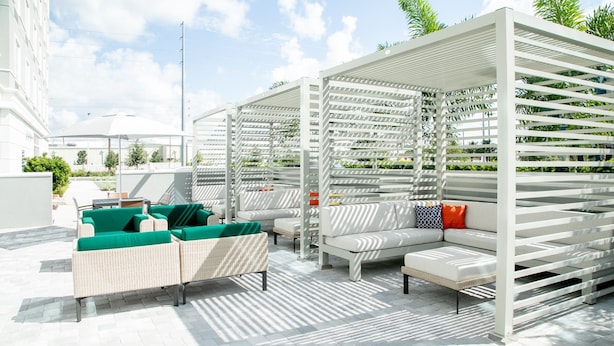 A rooftop lounge with outdoor seating and a pergola structure.