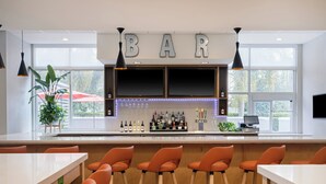 A bar area with a counter, bar stools, and a TV screen.