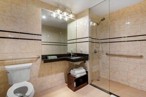 A modern bathroom with a toilet, sink, and shower. - The L Hotel (Brooklyn)