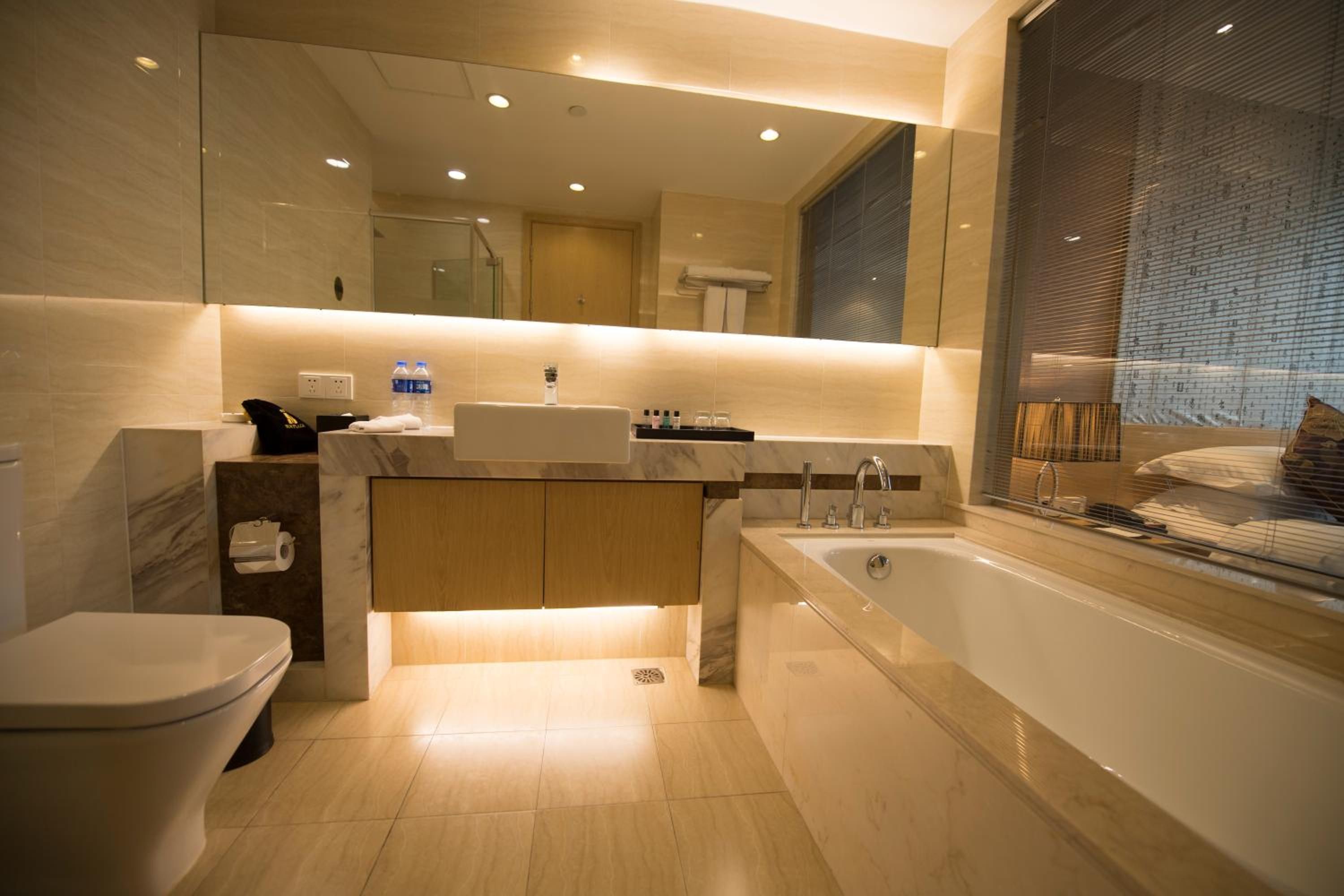 Une salle de bain moderne équipée de toilettes, d’un lavabo et d’une baignoire.