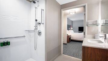 Un baño de hotel moderno con ducha, inodoro y lavamanos.