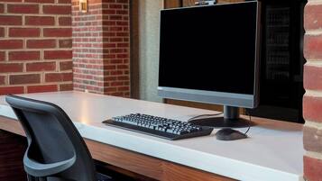 A modern workspace with a desktop computer, keyboard, and mouse on a white desk.
