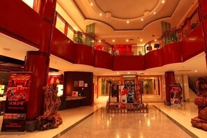 A hotel lobby with a central reception desk, multiple levels with balconies, and a modern architectural design. - Songling Hotel (Suzhou)