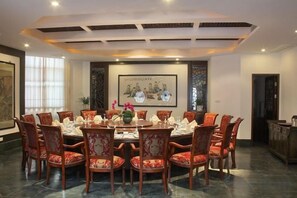A conference room with a round table, chairs, and a framed artwork on the wall. - Songling Hotel (Suzhou)