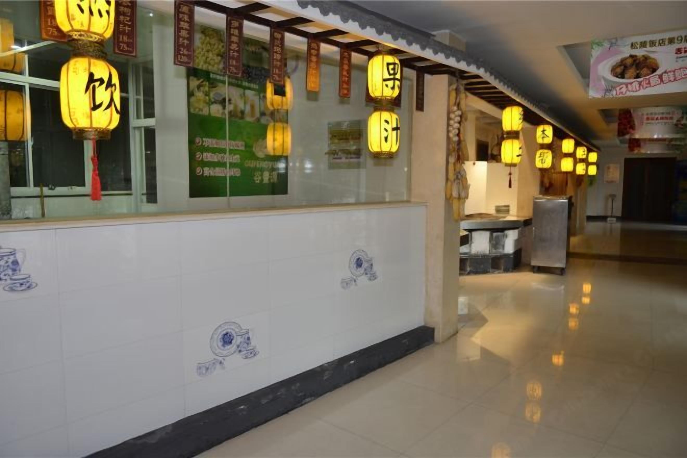 A corridor with traditional lanterns and tiled walls with blue patterns.