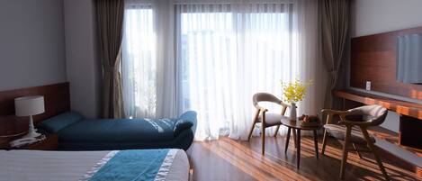 A hotel room with a bed, a desk, a chair, and a television.
